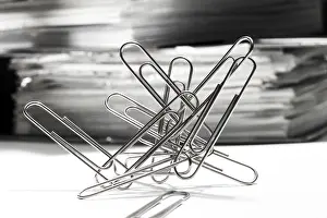 Office Supply Photography Drucke: Paperclips, paper clips in front of a stack of files