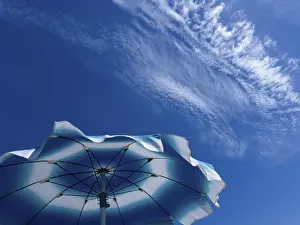 Cloudy Blue Skies Drucke: Parasol in front of a blue sky with clouds