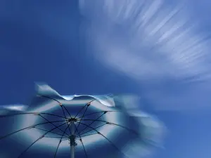 Global Warming Effects Drucke: Parasol in front of a blue sky with clouds