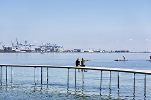 Drucke von Zwei Passanten bei der Bauweise einer kreisförmigen Brücke, Holzstege, Infinite Bridge auf Varna Beach, Ballehage Beach, Architekt Niels Povlsgaard, Blick auf den Containerhafen, Aarhus, Jütland Aarhus Drucke: Zwei Passanten auf der kreisförmigen Brücke beim Bau.