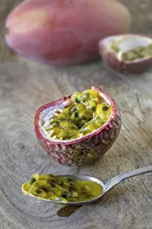 Tropical Fruit Drucke: A passion fruit, opened with pulp on a spoon