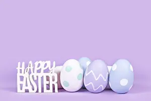Pastel Easter Eggs Drucke: Pastel colored easter eggs and text Happy Easter on violet background with copy space