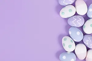 Christian Tradition Drucke: Pastel colored painted easter eggs on side of violet background with copy space