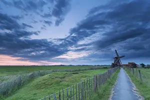 Drucke von Weg zur Windmühle in bewölktem Abenddämmer, Groningen, Niederlande Groningen Drucke: Weg zur Windmühle in bewölktem Abenddämmerung.