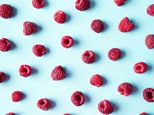 Flat Lay Fruit Photography Drucke: Pattern of ripe red raspberry on blue background