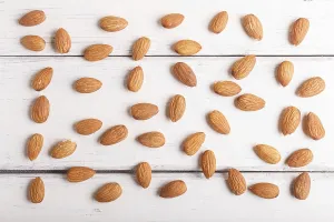 Healthy Eating Image Drucke: Pattern and texture made from almonds on white wooden background