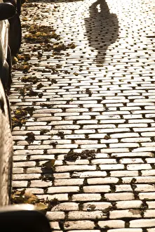Evening Atmosphere In Europe Drucke: Pedestrian, shadow on cobblestones