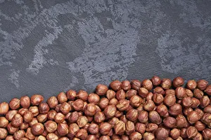 View From Above Drucke: Peeled hazelnuts on black table