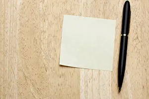 Deserted Office Scene Drucke: Pen and post it notes pad against a wood background