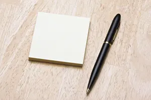Deserted Office Scene Drucke: Pen and post it notes pad against a wood background