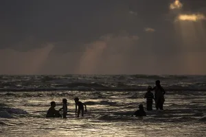 Atmospheric Evening Atmosphere Drucke: People in backlight in water, rays of sunlight