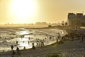 Beach At Sunset Drucke: Many people bathing on the beach at sunset