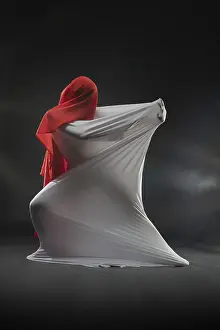 Female Figure Pose Drucke: A performer is wrapped in flowing white and red fabrics in a dramatic studio setting