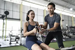 Fitness Exercise Drucke: A personal trainer explains the rowing technique to a female client