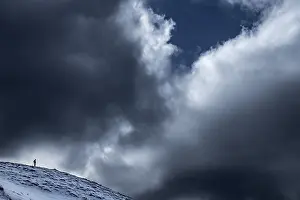 Dramatic Mountain Landscape Drucke: Photographer on ridge with dramatic cloudy sky