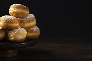 Empty Room For Text Drucke: Pile of doughnuts on a rustic plate in front of a dark background