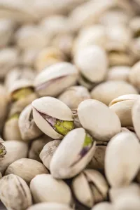 Wooden Background Image Drucke: Some whole Pistachios (selective focus)