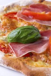 Close Up Pizza Drucke: Detail of a pizza with ham and basil
