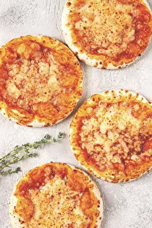 Vegetarian Dishes Drucke: Four pizzetta Margaritas, on a light grey surface