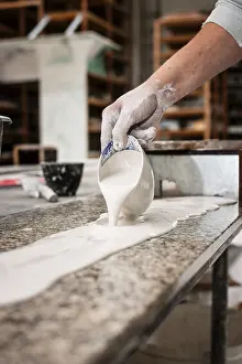 Handicraft Skills Drucke: A plasterer pours plaster onto a workbench