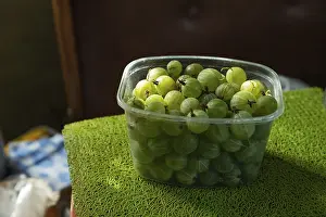 Natural Light Photography Drucke: Plastic container with green gooseberries on the kitchen table