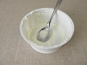 Disposable Tableware Drucke: Empty plastic cup with leftover yoghurt and a spoon