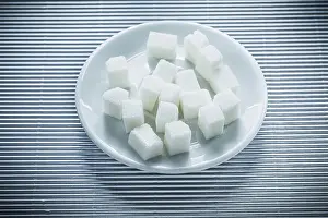 Sugar Cubes Drucke: Plate with sugar cubes on striped background