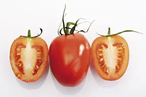 Studio Shot Of Tomatoes Drucke: Plum tomatoes, one halved and one whole