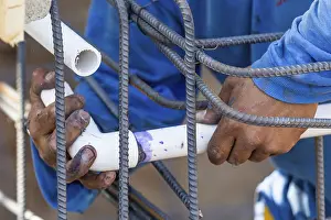 Construction Site Worker Drucke: Plumber installing PVC pipe at construction site