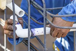 Deserted Construction Area Drucke: Plumber installing PVC pipe at construction site