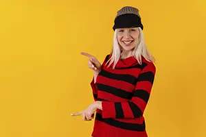 Studio Shot Yellow Background Drucke: Pointing to the left in a wool cap
