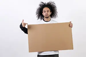 Young Man With Afro Hair Drucke: Pointing to a sign with copy paste space