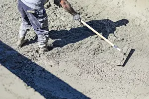 Pool Construction Site Drucke: Pool construction worker working with A bullfloat on wet concrete