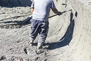 Cement Finishing Techniques Drucke: Pool construction worker working with A bullfloat on wet concrete