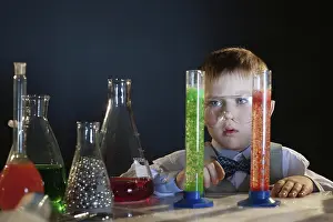 Boy Looking At Camera Drucke: Portrait of adorable boy posing in studio with flasks
