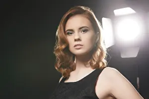Sensual Female Portrait Photography Drucke: Portrait of beautiful model posing in studio on background of spotlight