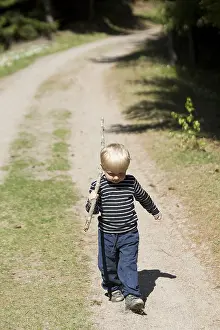 Young Boy Looking At Camera Drucke: Portrait of boy walking on path