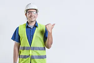 Young Engineer Drucke: Portrait of engineer man pointing to side isolated