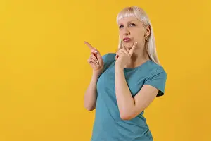 Blonde Woman Looking At Camera Drucke: Portrait with pensive pointing posture