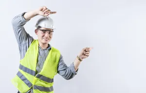 Young Engineer Drucke: Portrait of smiling engineer pointing aside isolated