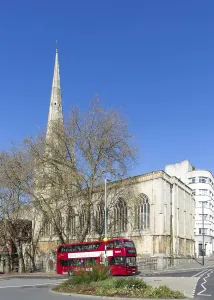 Bristol Cityscape Photography Drucke: Red double-decker bus passing Church of Saint Nicholas