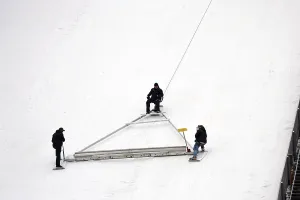 Ski Jumping World Cup Drucke: Using an oversized rake attached to a cable winch
