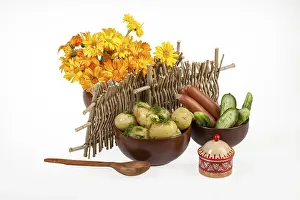 Studio Shot Of Tableware Drucke: Potatoes, greenery and tableware on isolated satudio background