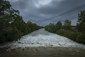 Uninhabited Waterfront Drucke: A powerful river with a strong current under a cloudy sky