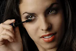 Female Make Up Artist Drucke: Pretty lady doing makeup using eyelash brush
