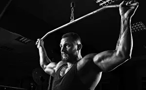 Professional Athlete Training Drucke: Professional athlete performs an exercise in the gym