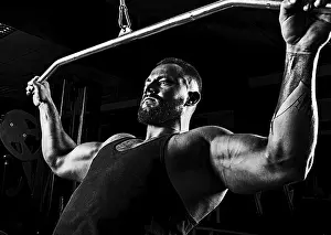 Fitness Training For Men Drucke: Professional athlete performs an exercise in the gym