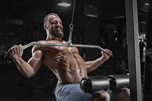 Fitness Studio Training Session Drucke: Professional athlete performs an exercise in the gym