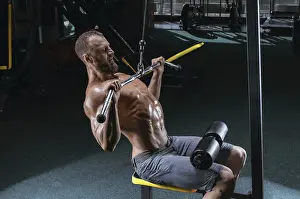 Muscular Physique Drucke: Professional athlete performs an exercise in the gym