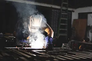 Factory Worker Safety Drucke: Professional welder working at the workbench